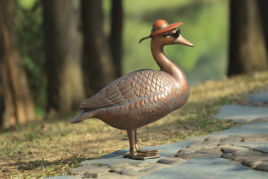 A sculpture of a duck wearing sunglasses and a sunhat.