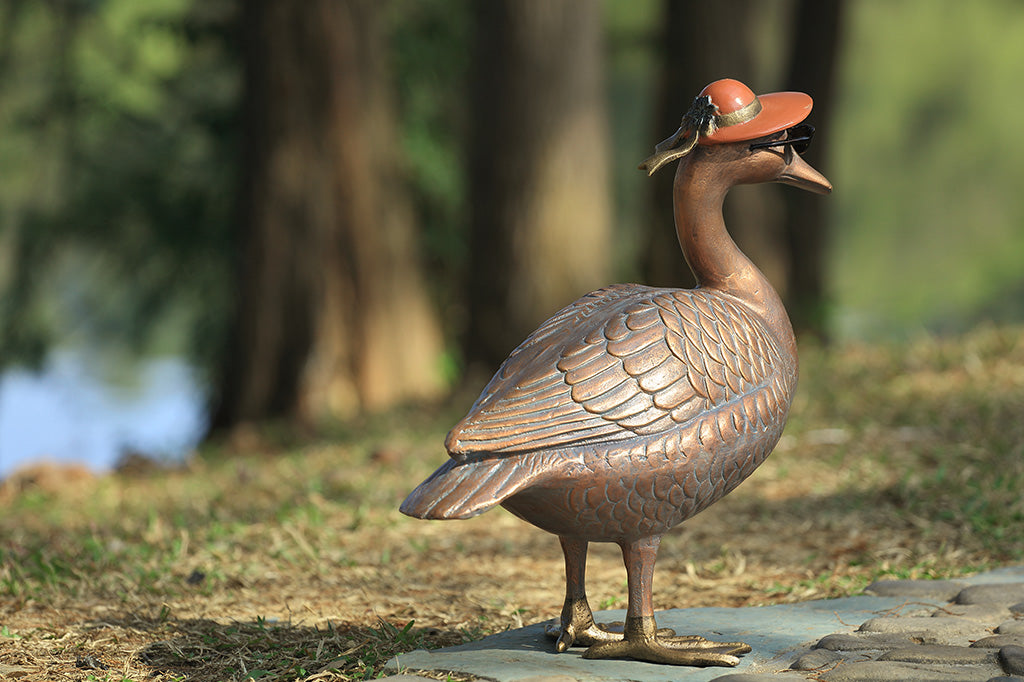 A sculpture of a duck wearing sunglasses and a sunhat.