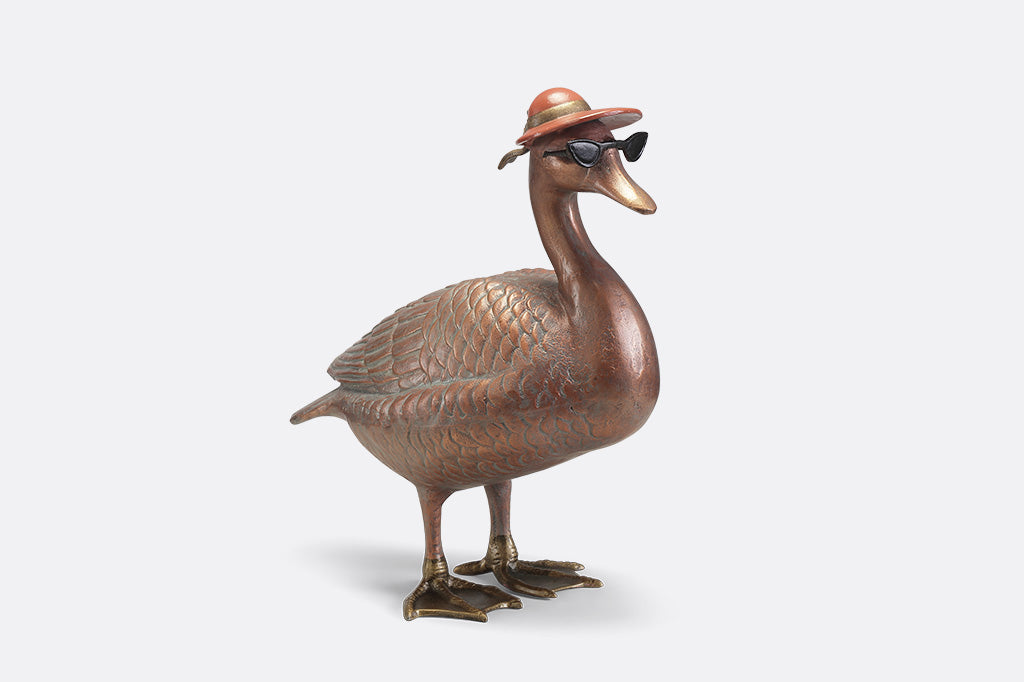 A sculpture of a duck wearing sunglasses and a sunhat.