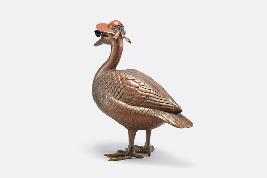 A sculpture of a duck wearing sunglasses and a sunhat.
