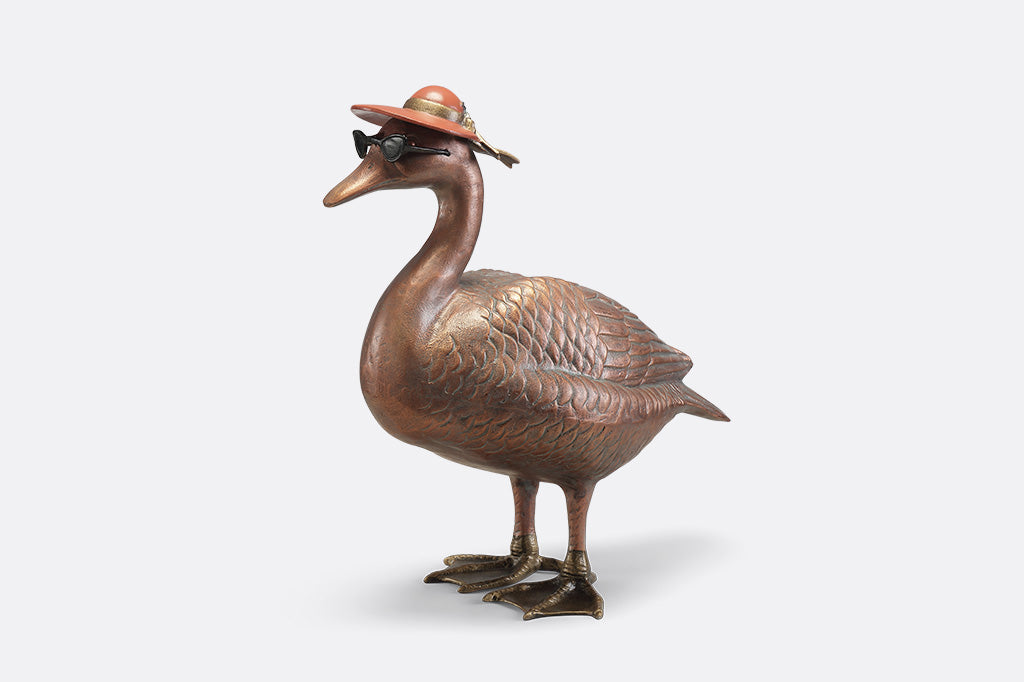 A sculpture of a duck wearing sunglasses and a sunhat.