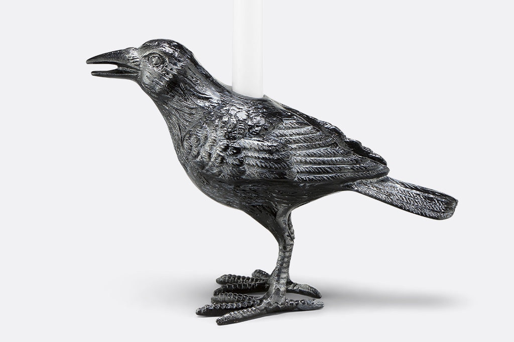 upright raven taper candle holder on a white background