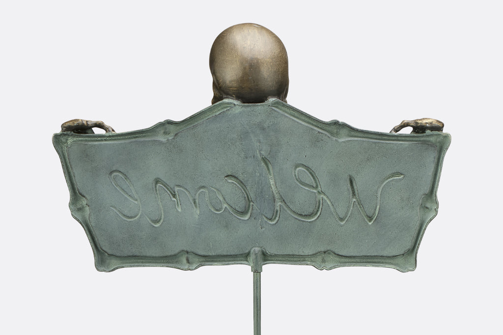 back of cast metal sign, imprint of cursive welcome
