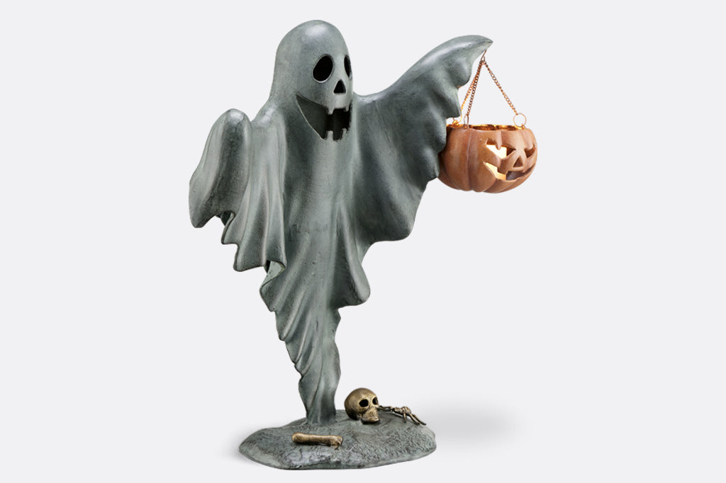 cast metal smiling ghost holding jack o lantern with candle inside