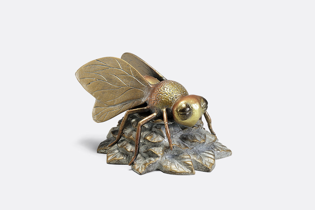 A statue of a bee landing on a flower.