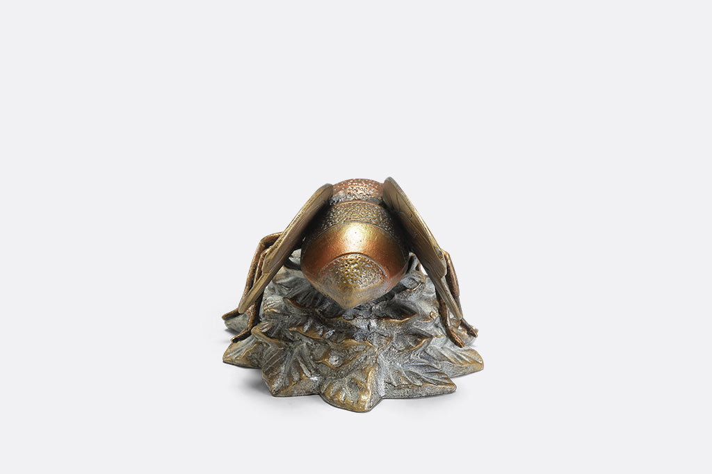 A statue of a bee landing on a flower.