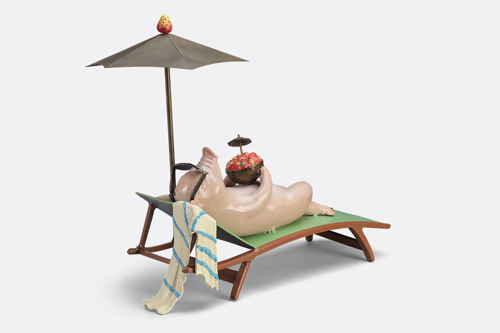 Decorative figurine of a pig on a beach chair with an umbrella