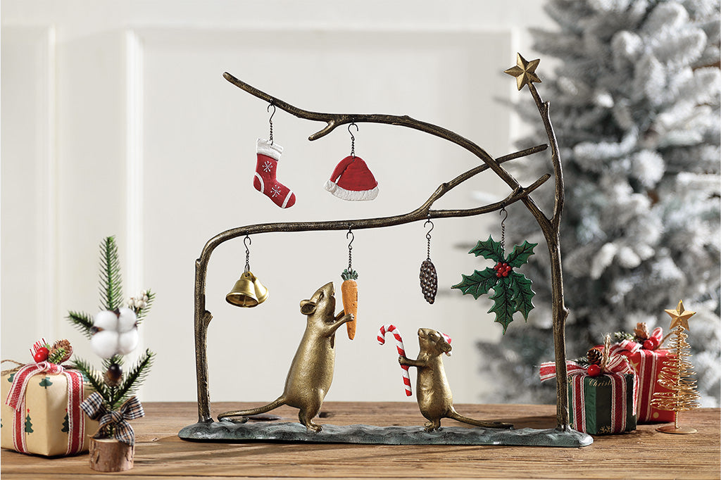 Decorative scene with mice, Christmas decorations, and presents on a wooden surface.