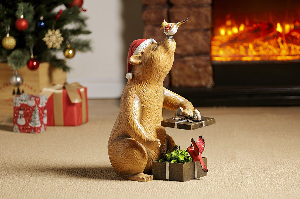 A heartwarming sculpture of a bear opening presents with his bird friends.