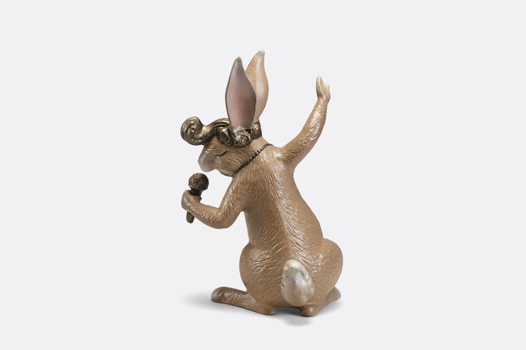 A sculpture of a rabbit with swept up hair, necklace, and a microphone.