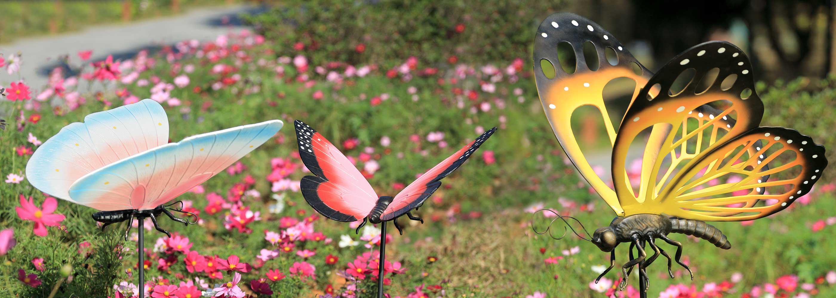 Butterfly-shaped garden stakes with colorful wings in a garden setting.