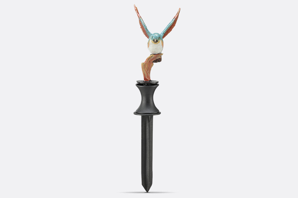 A hose guard of a bird landing upon a leaf.