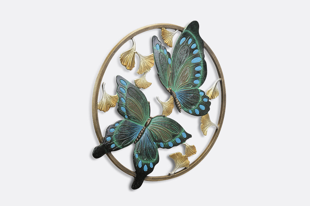 Circular wall art piece with ginkgo flowers and two blue and green butterflies.
