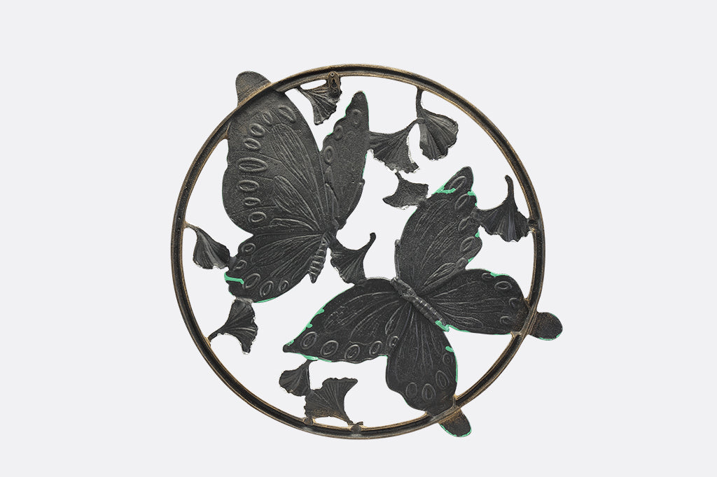Circular wall art piece with ginkgo flowers and two blue and green butterflies.