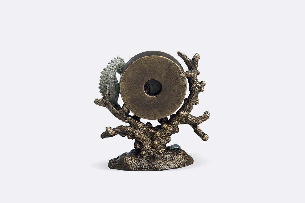 Clock with organic ocean like inspired design and a seahorse attached from back angle