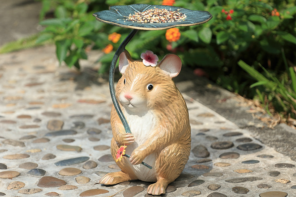 A sculpture of a hamster holding a leaf and flower