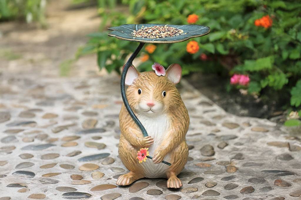 A sculpture of a hamster holding a leaf and flower