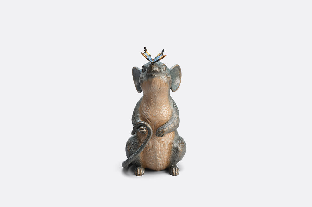 Statue of a mouse with a butterfly on its nose on white background