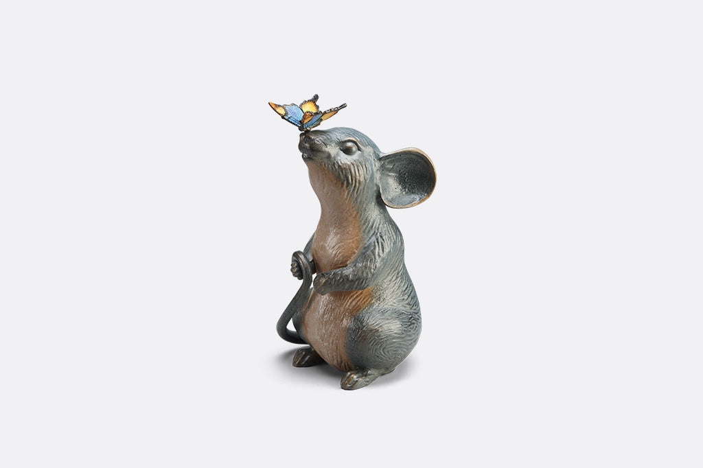 Statue of a mouse with a butterfly on its nose on white background