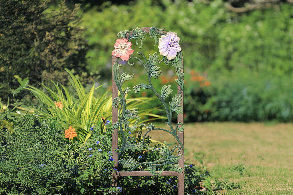 A decorative garden trellis featuring blooming lilies and branches.
