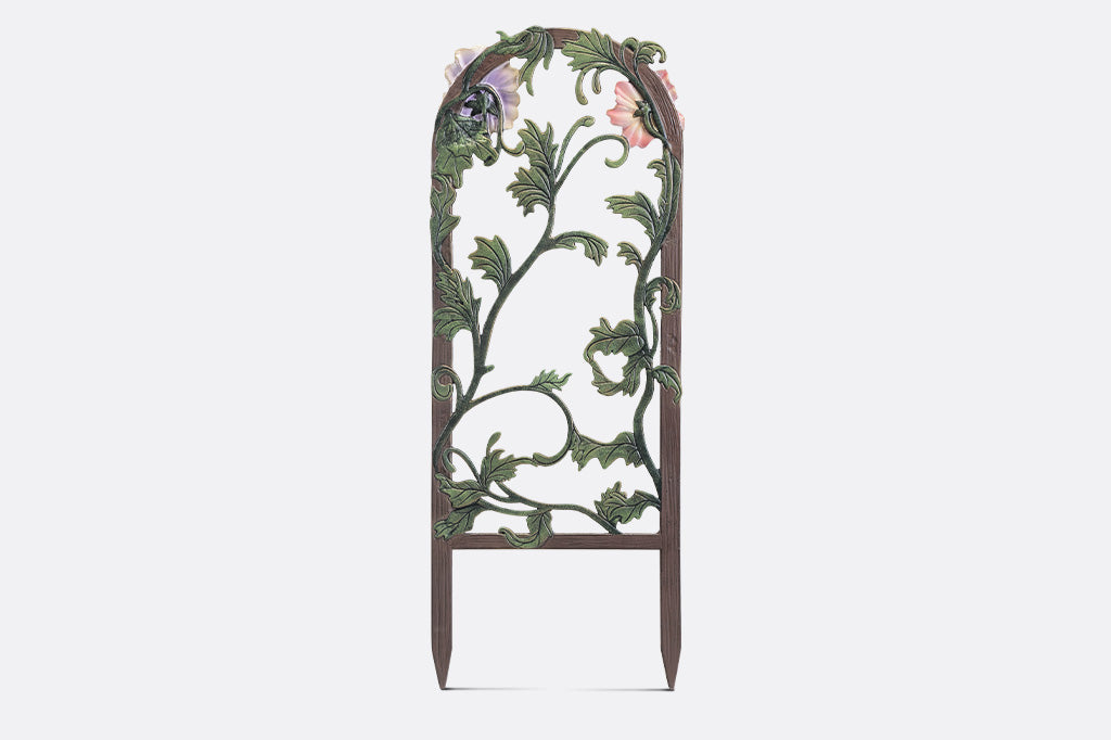 A decorative garden trellis featuring blooming lilies and branches.