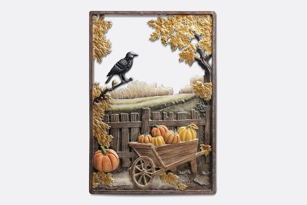 Decorative sign with pumpkins, a wheelbarrow, and autumn leaves on a white background