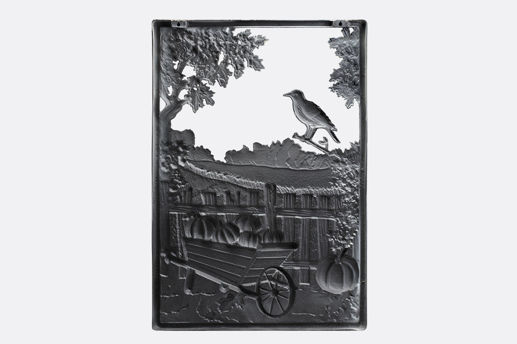 Decorative metal wall art with a landscape design featuring a wagon and trees on a white background.