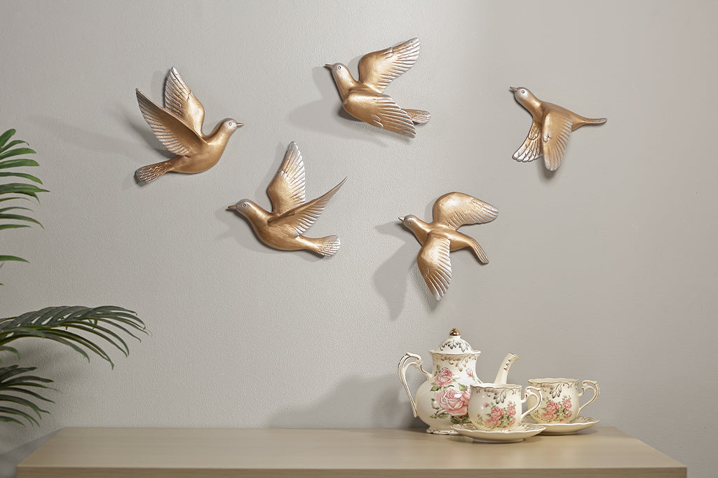 A set of 5 gold birds posed in flight.