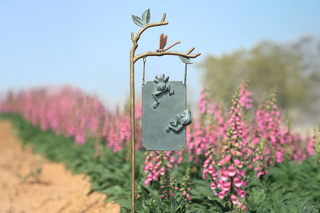 A staked sign with frogs, dragonflies, and branches, with a sign that reads "Frog Parking Only. All others will be toad."