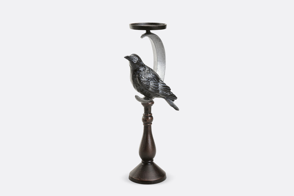 Decorative candle holder with a bird design on a white background