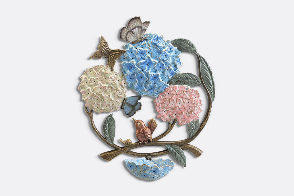 A round, wall mounted bird feeder with details of hydrangeas, leaves, birds, butterflies, and snails.