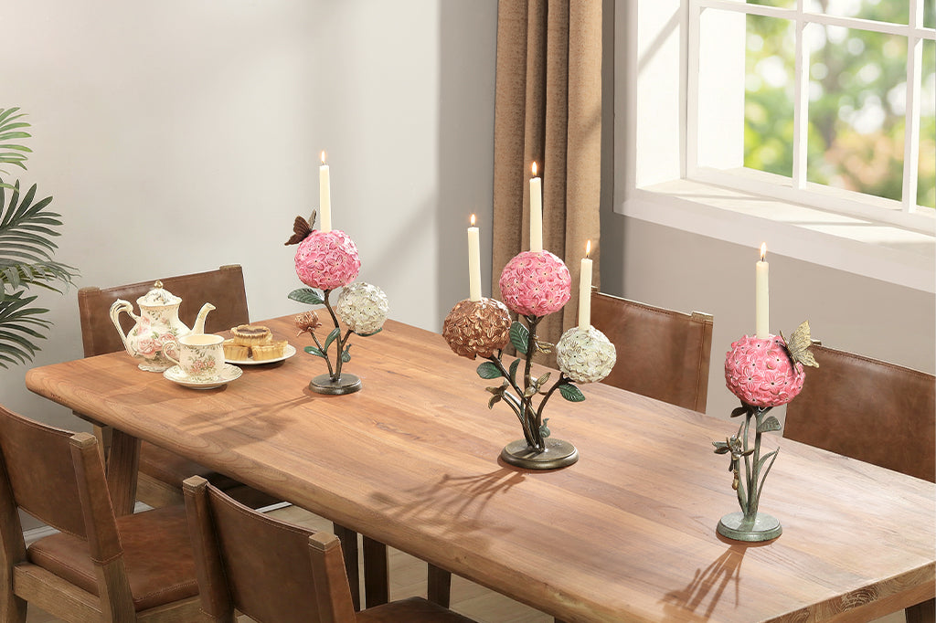 A single taper candle candle holder with two blooming hydrangeas, a butterfly, and a snail.