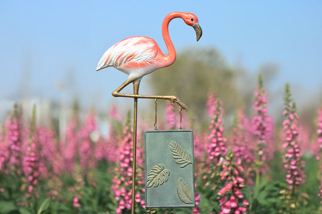 A staked garden sign of a flamingo that says "Welcome! Come be fabulous."