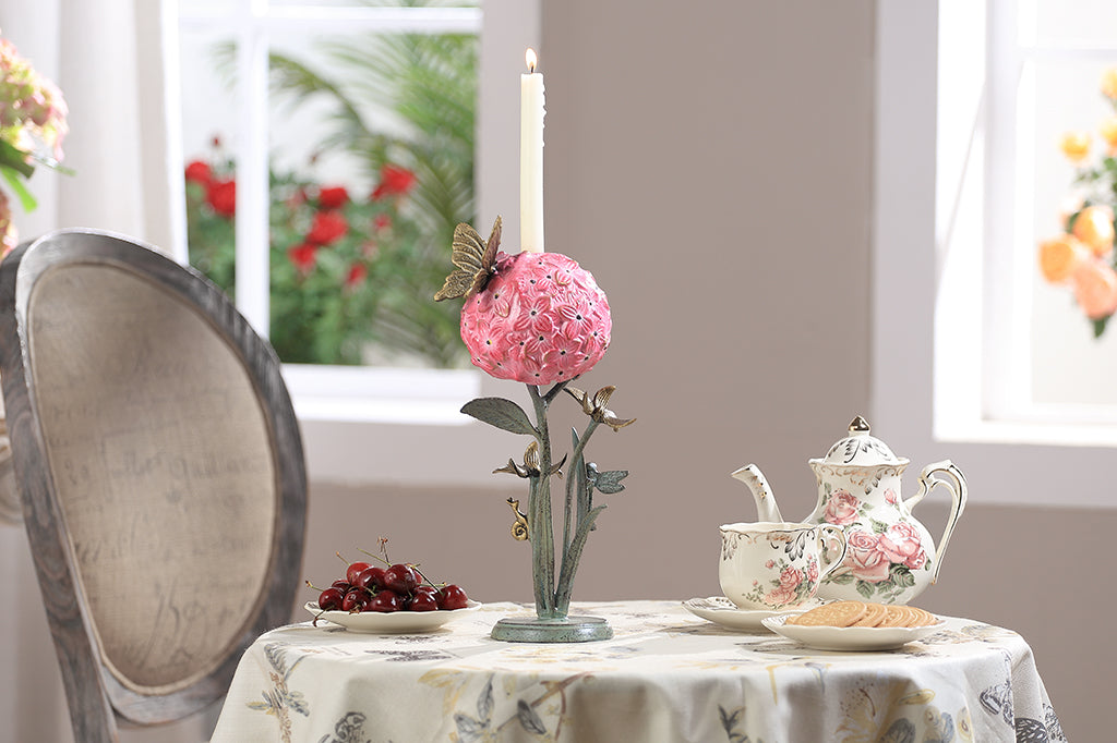 A single taper candleholder of a hydrangea blossom surrounded by a butterfly, dragonfly, and a snail.