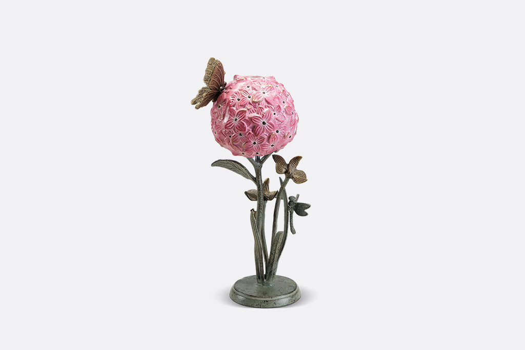 A single taper candleholder of a hydrangea blossom surrounded by a butterfly, dragonfly, and a snail.