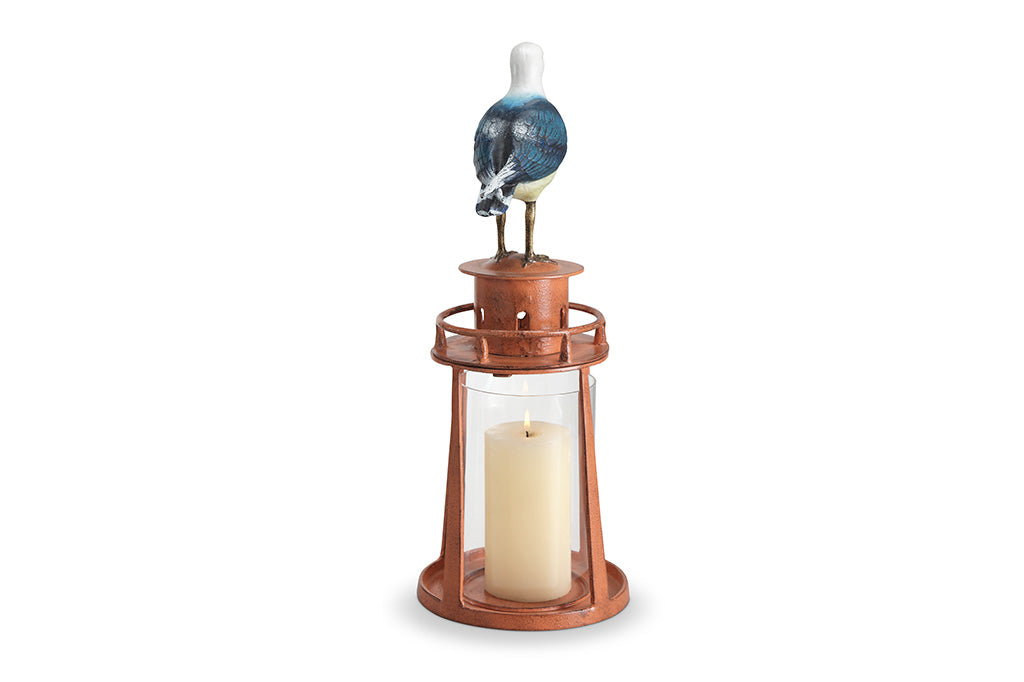 Decorative lighthouse with a seagull and candle inside on a white background