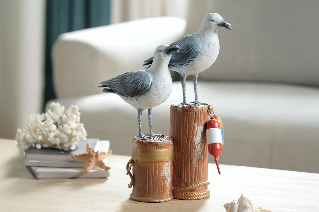A sculpture of two seagulls standing atop the supporting beams of a dock adorned in buoys and rope.