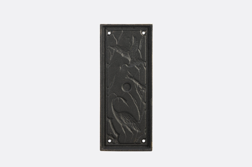 A doorknocker with embossed cranes and wildlife.