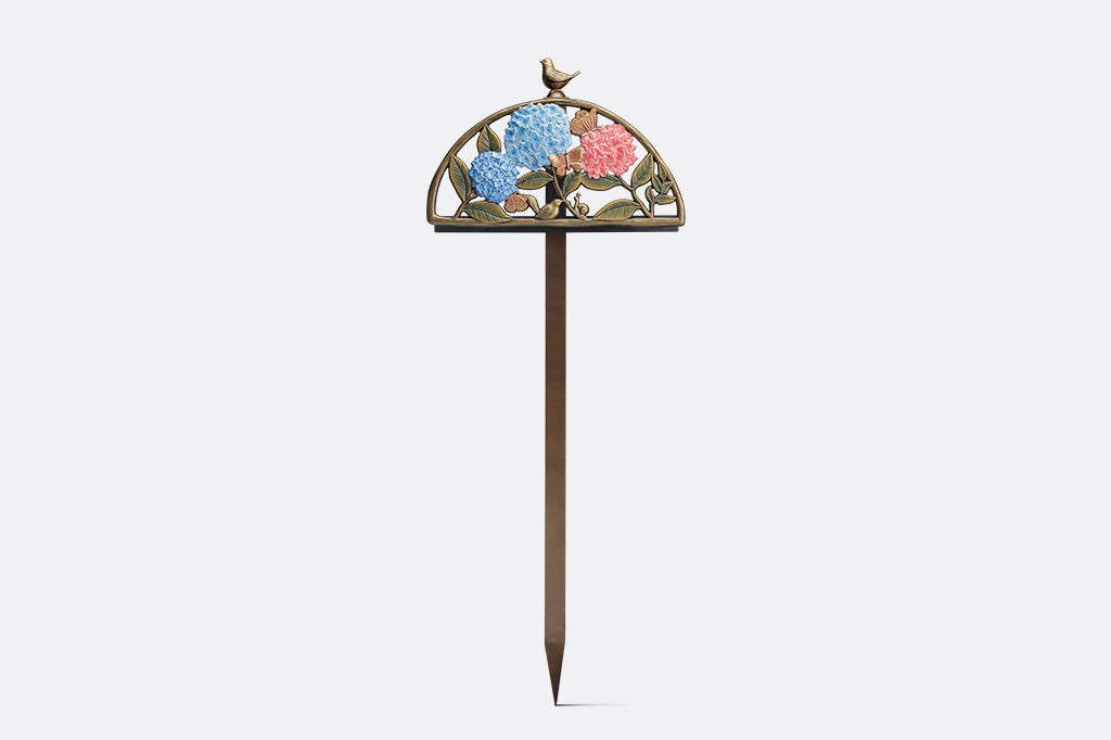 Decorative garden hose holder with floral design on a white background