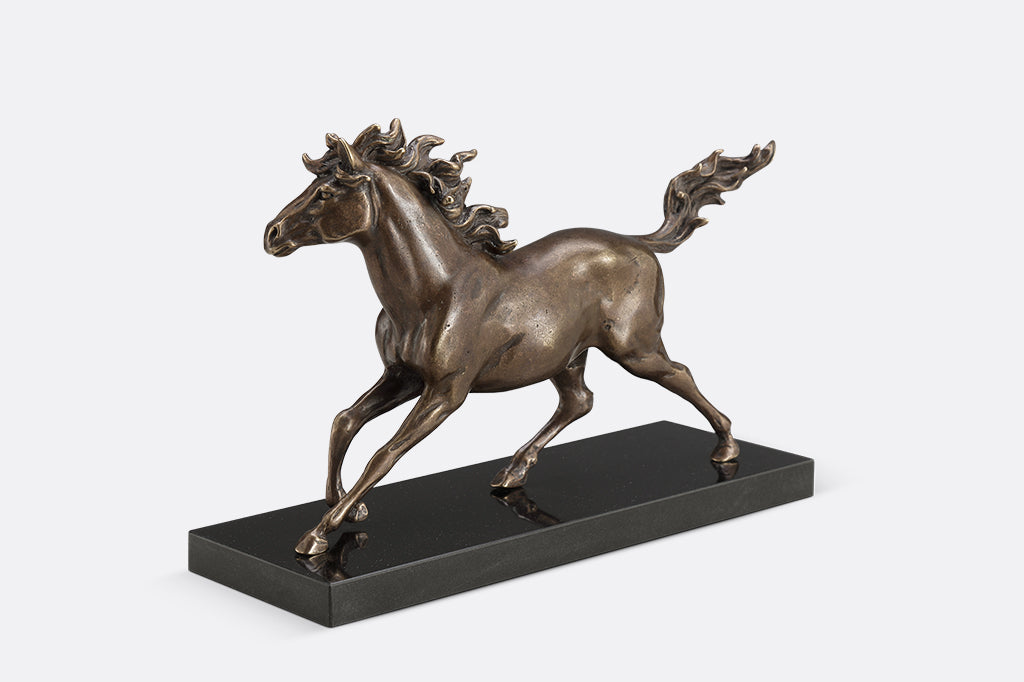 Brass sculpture of a horse running on a marble base.