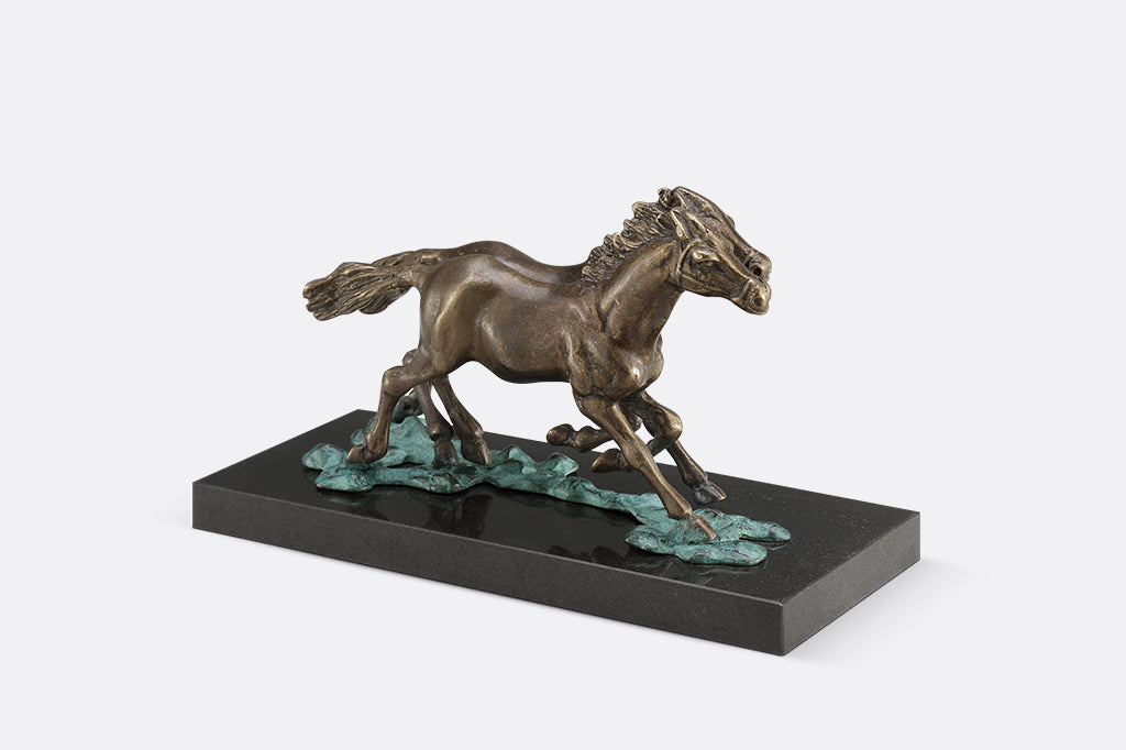 Brass sculpture of two horses running on water on a marble base.