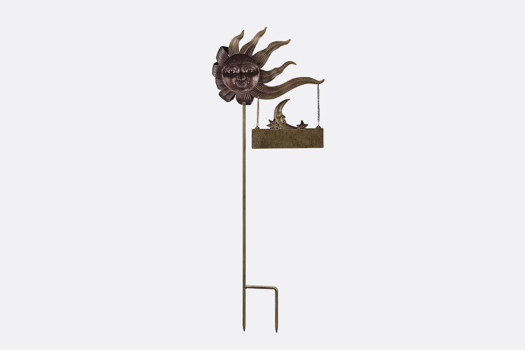 The back view of a decorative garden stake with sun face and 'Welcome' sign on a white background