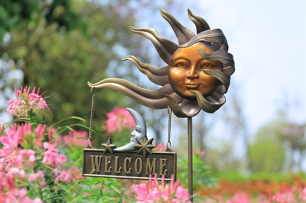 Sun shaped garden stake with welcome sign attached to two stars and a moon shaped details.