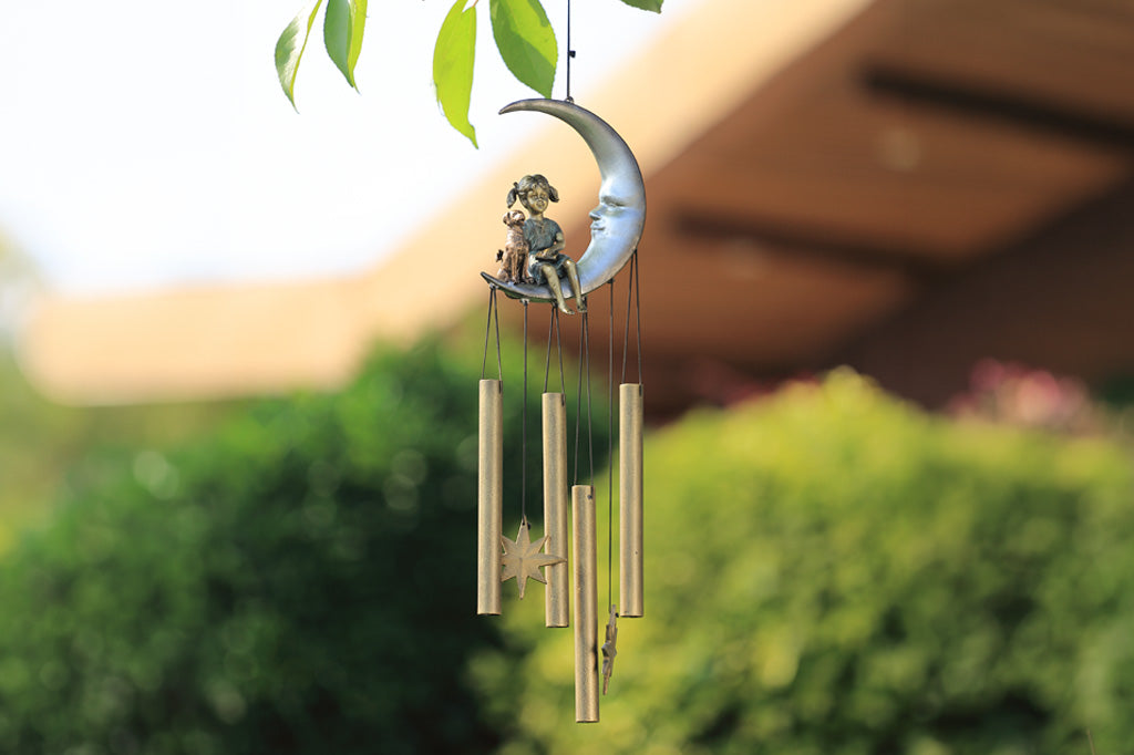 windchime garden decor with girl and pet dog sitting on a crescent moon. bronze tube chimes and star pendants