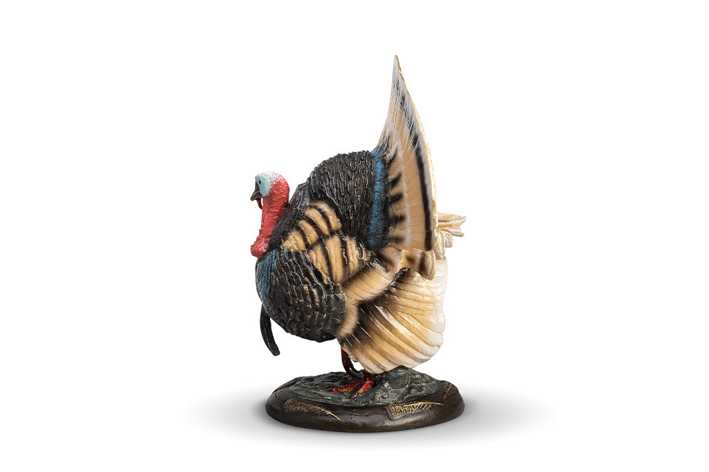A colorful turkey sculpture with its feathers spread out.