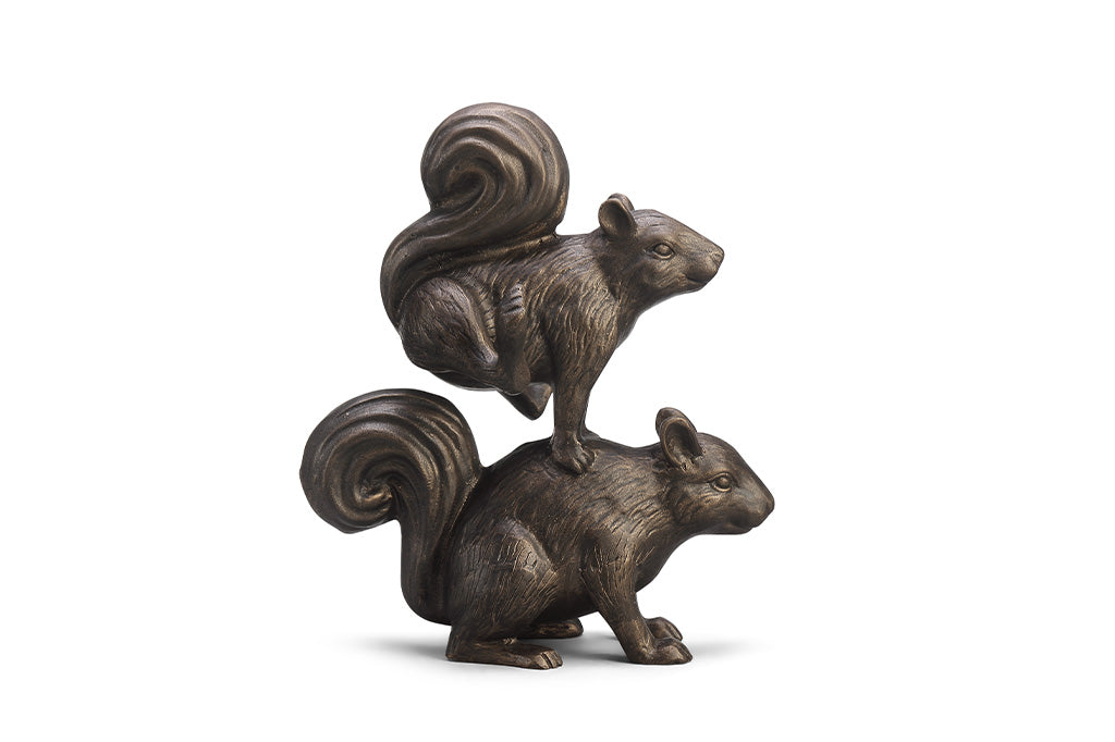 A sculpture of two squirrels playing leapfrog and hopping over each other.