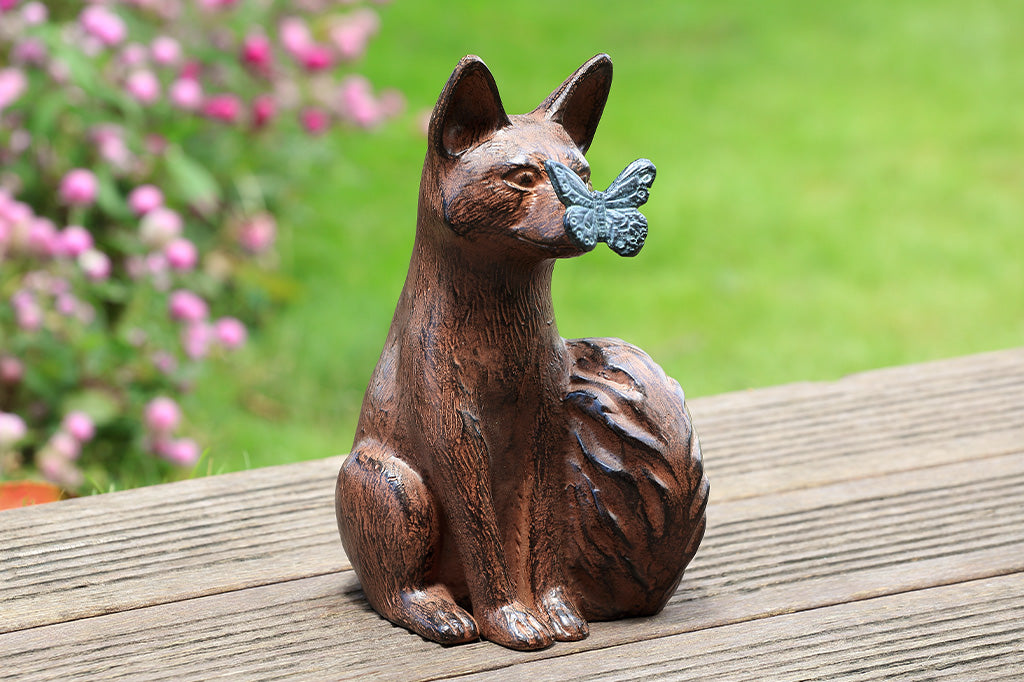 A sculpture of a blue butterfly landing on the nose of a fox.