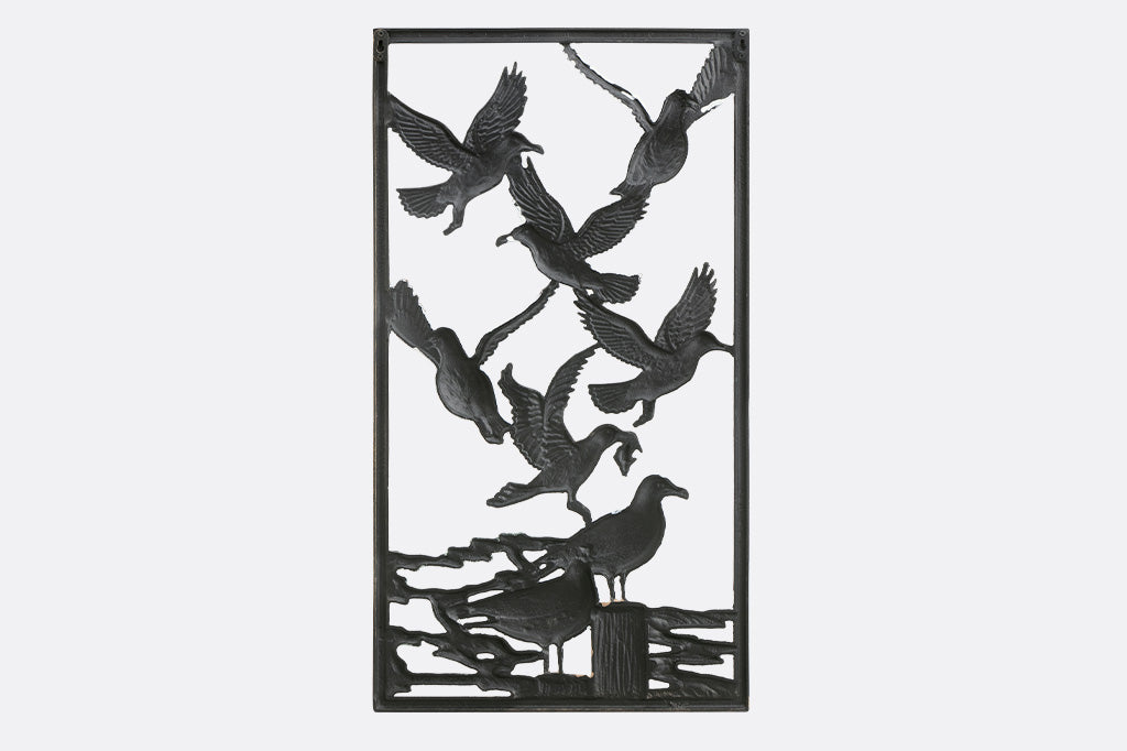 Decorative metal panel with cut-out design of birds on a white background