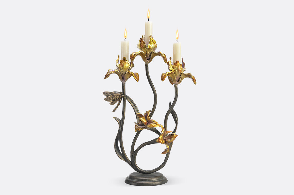 A taper candleholder shaped like Iris flowers with a dragonfly.