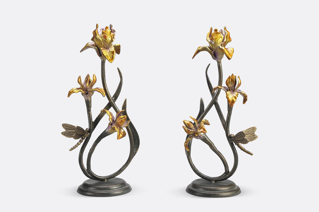 A pair of taper candleholders shaped like iris flowers with a dragonfly.